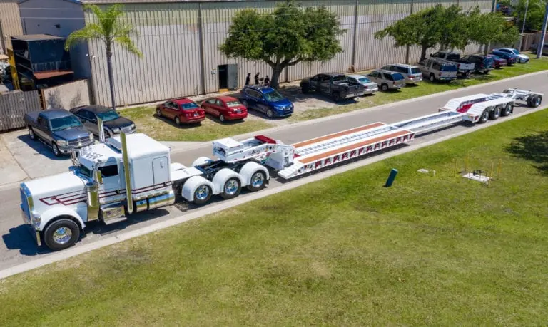 White Globe lowboy trailer and tractor viewed from above outside the Bradenton manufacturing facility